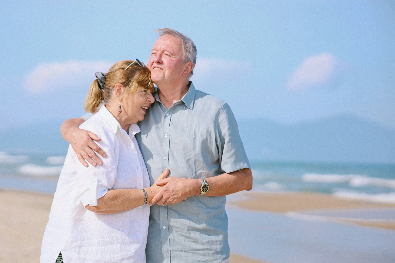 Elderly couple embracing on a sunny beach
