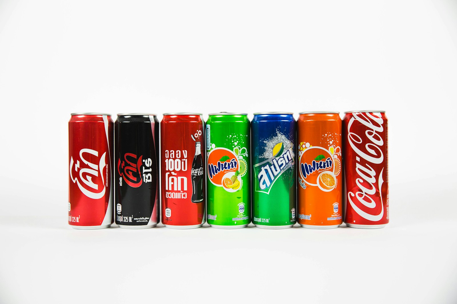 Seven assorted brand soda cans