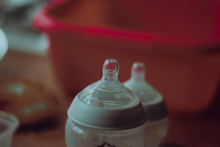Clear plastic feeding bottle on red table