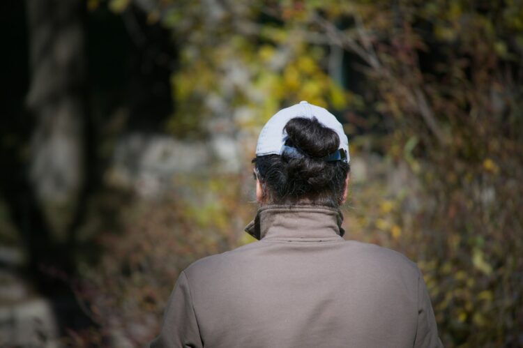 Woman with hair in bun wearing baseball cap
