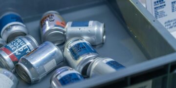 a metal bin filled with cans of soda