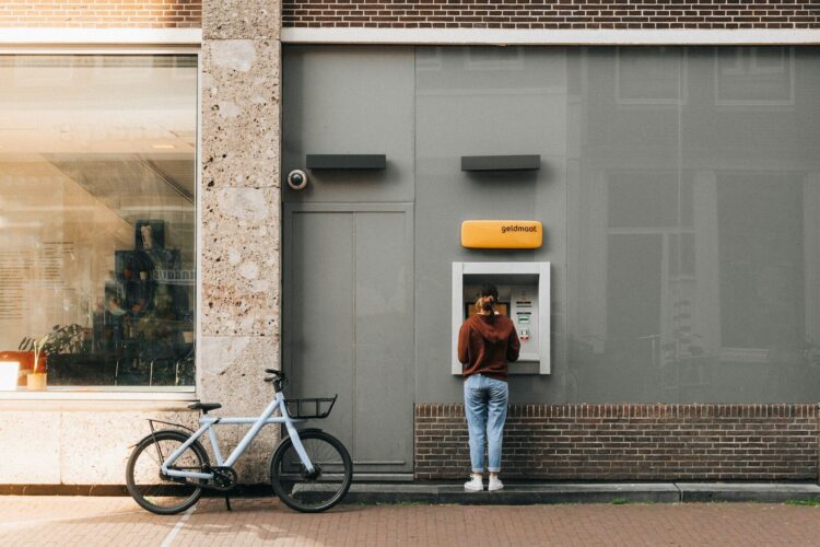 A person standing in front of a atm machine