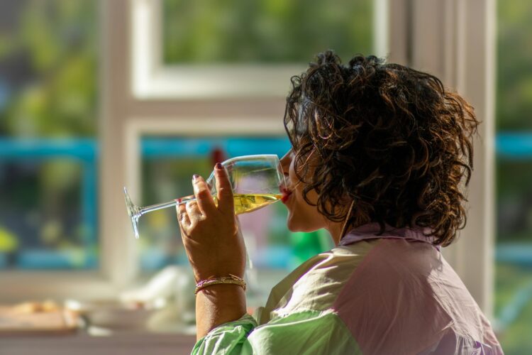 A woman drinking a glass of white wine