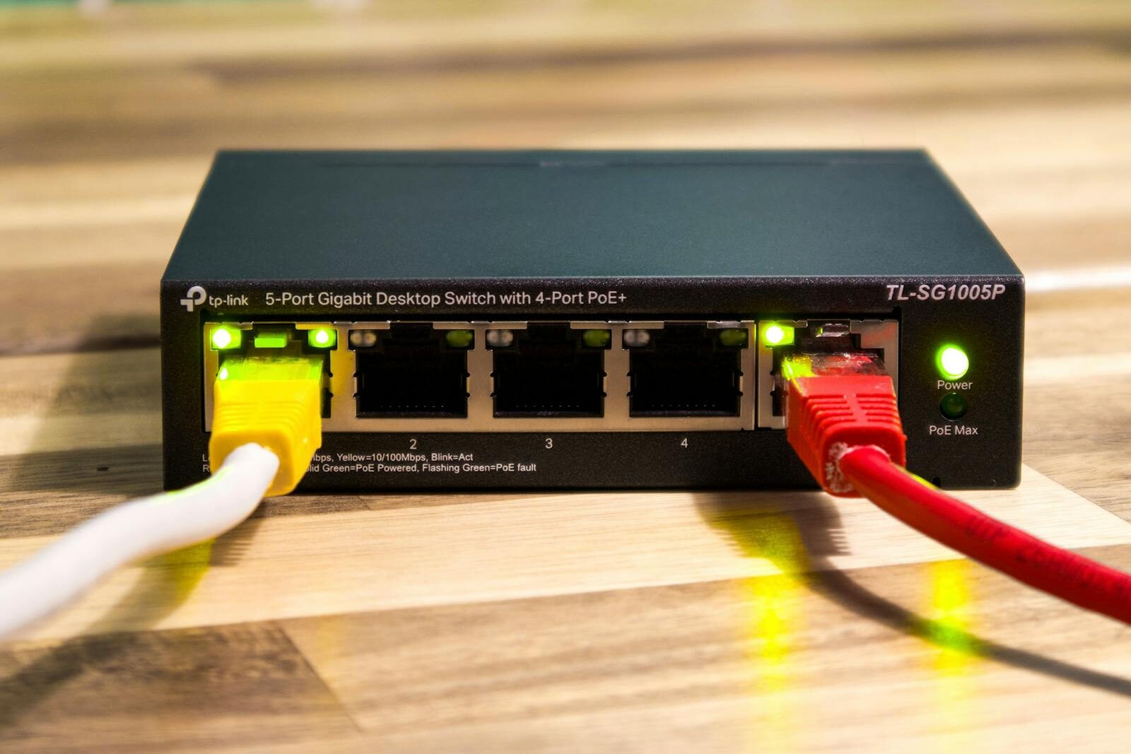 Close up of a tp link ethernet switch with yellow red and white cables connected