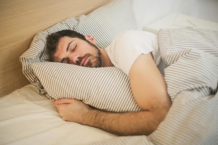 Man sleeping peacefully on striped bedding embracing relaxation and comfort
