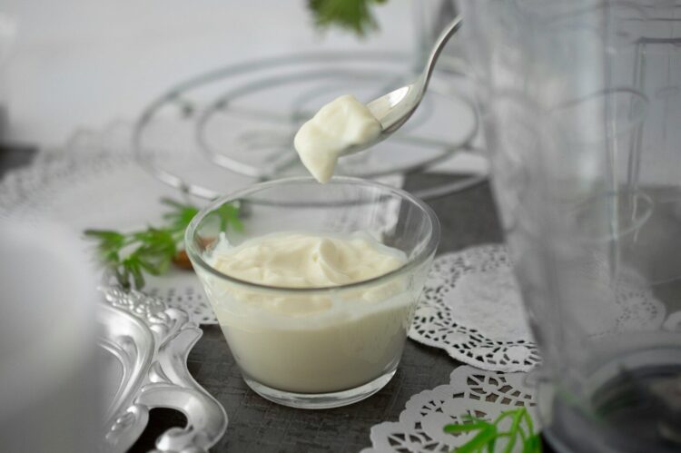 Close up photo of white cream in clear shot glass