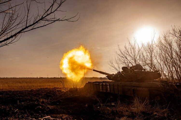 A tank that is on fire in a field
