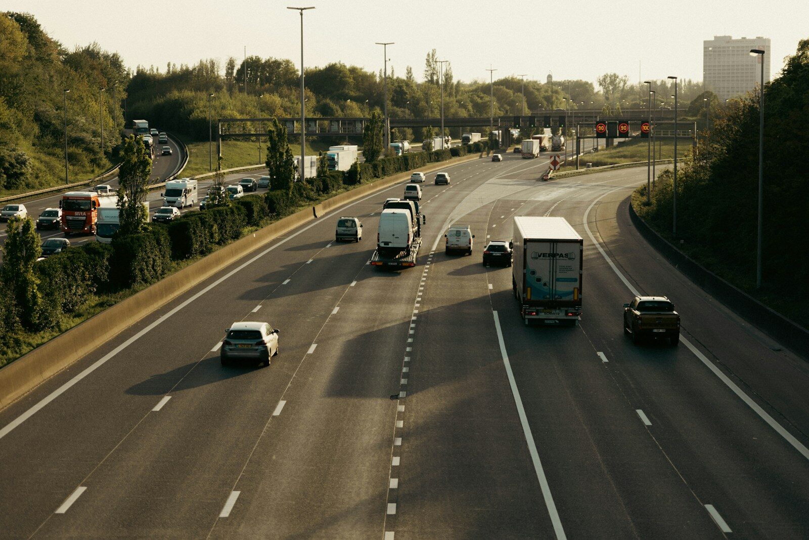 A highway filled with lots of traffic next to trees