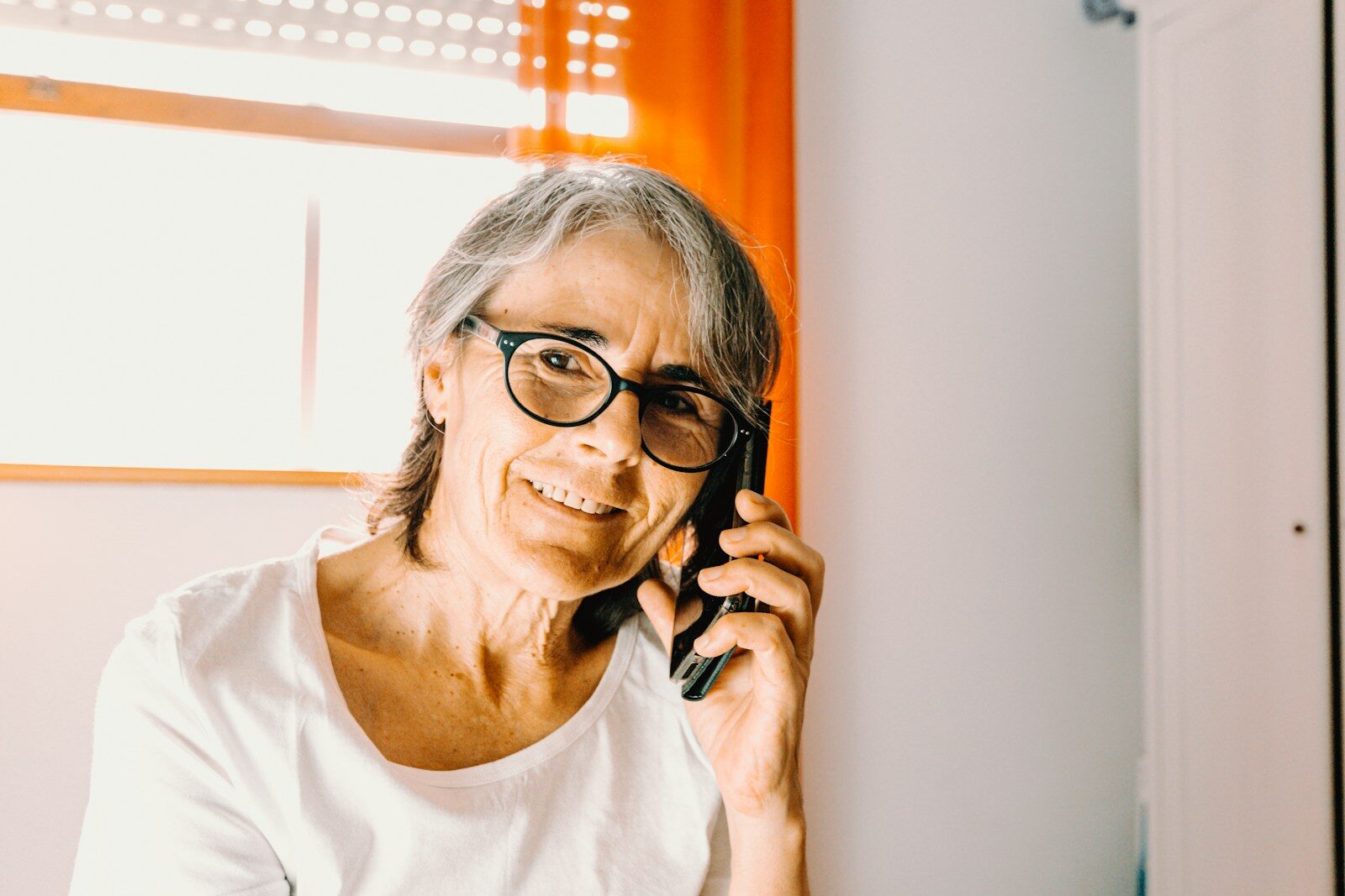 Woman in white scoop neck shirt wearing black framed eyeglasses