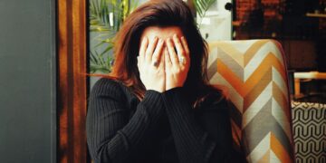 woman in black long sleeve shirt covering her face