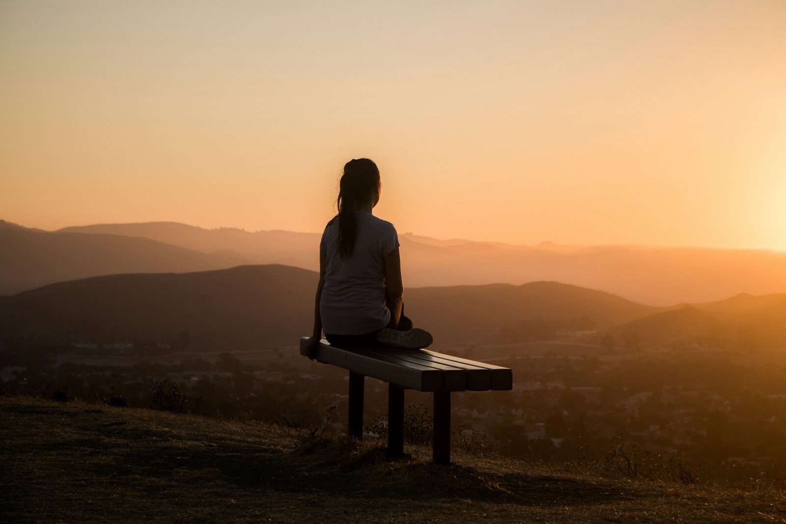Photo by Sage Friedman - Info Vandaag Woman sitting on bench over viewing mountain