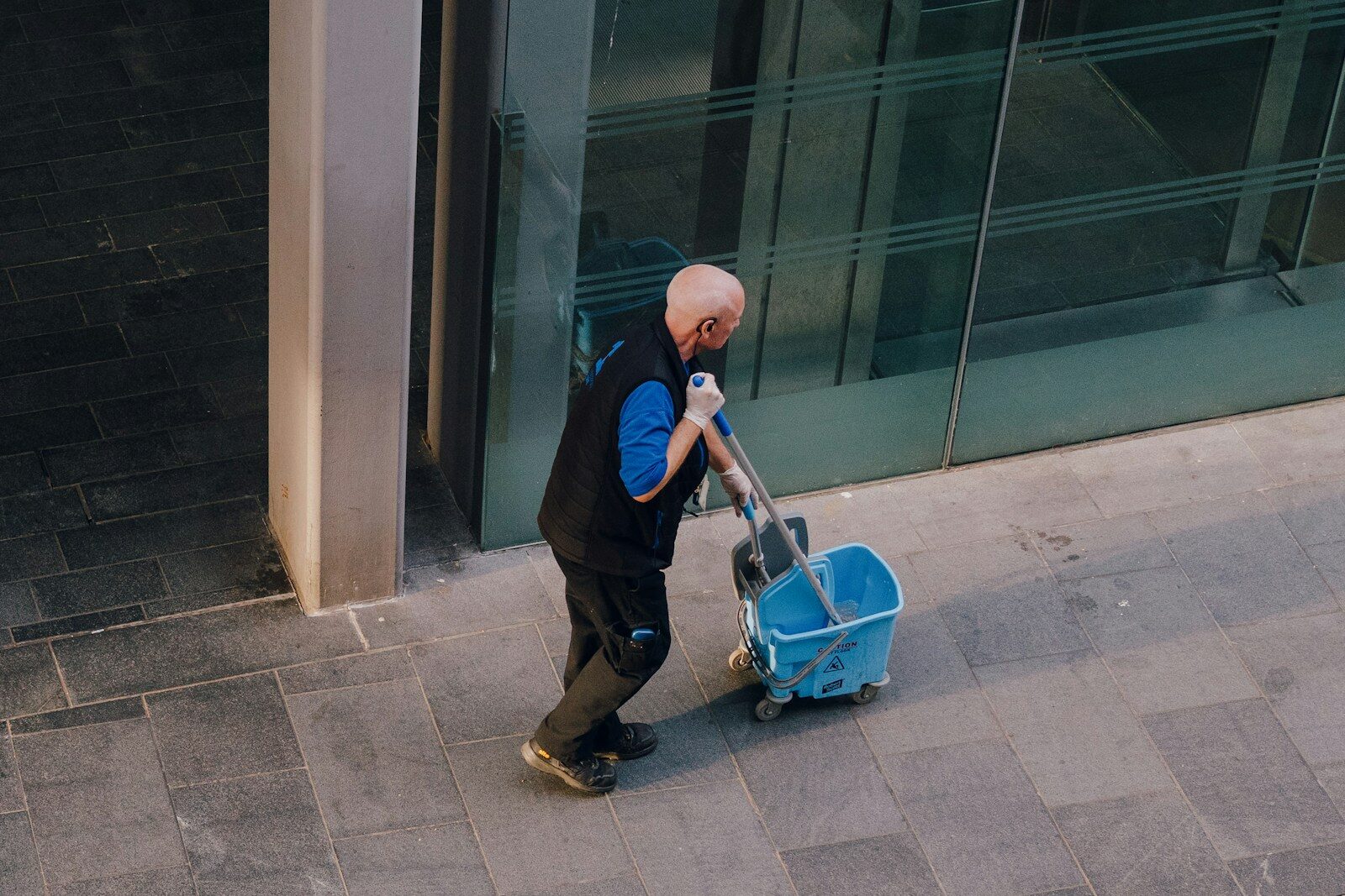 Photo by Raymond Okoro - Info Vandaag A man pulls a cleaning cart near a building