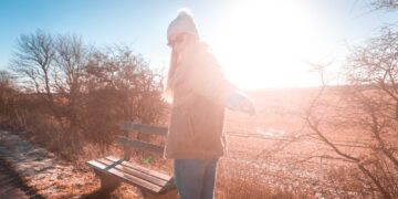woman wearing brown coat near bench