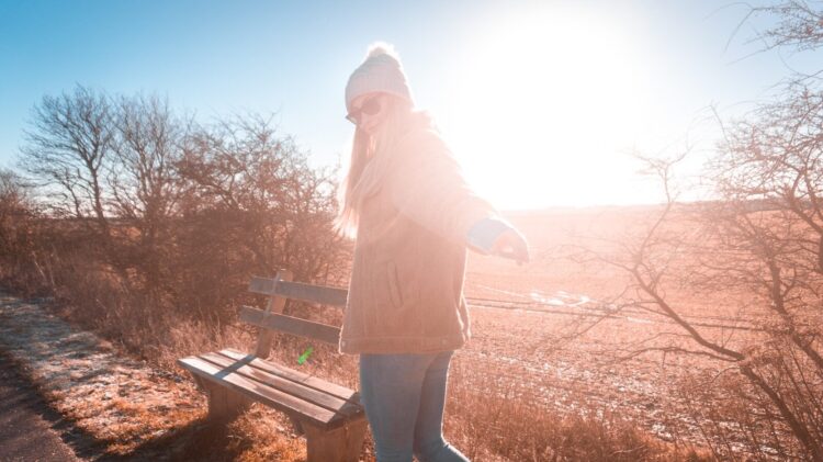 Woman wearing brown coat near bench