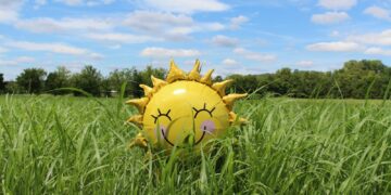 yellow inflatable sun at grass field