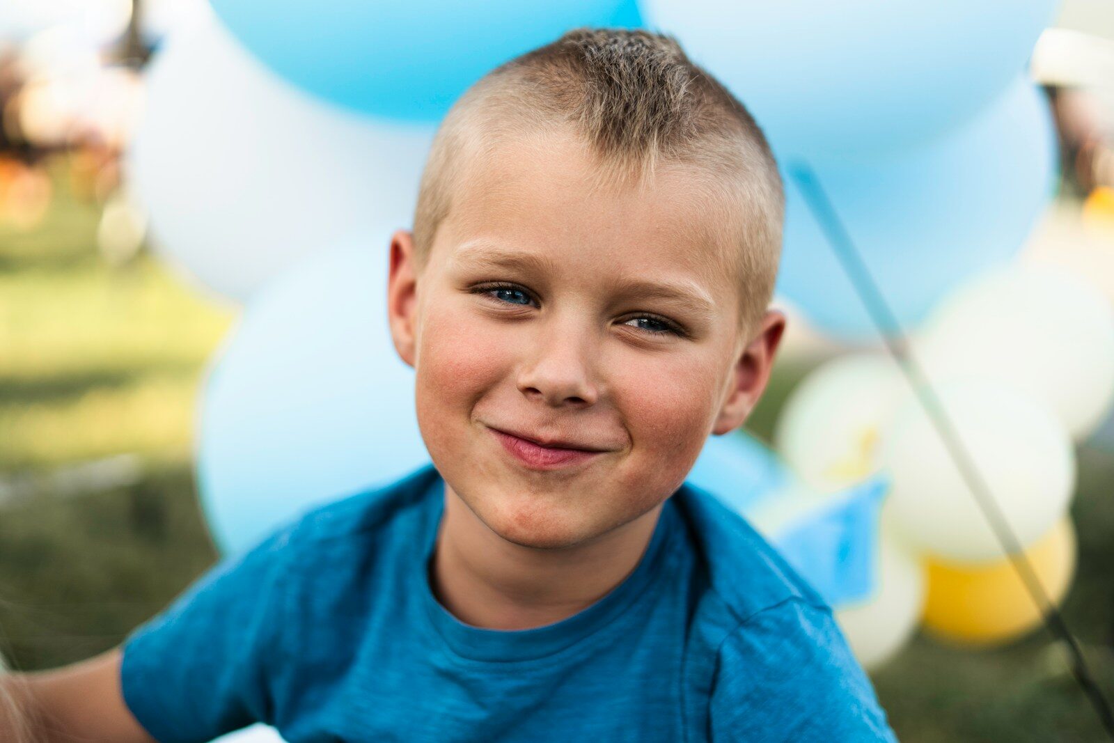 Photo by Brayden Prato - Info Vandaag A young boy smiles at the camera with balloons in the background