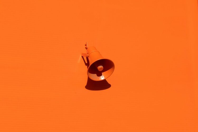 Orange megaphone on orange wall