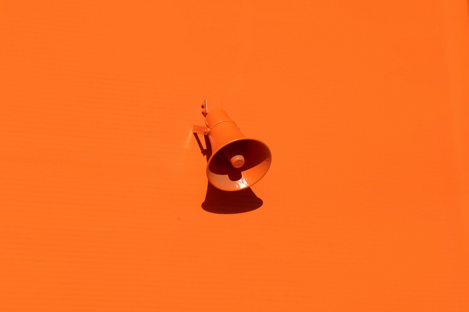 Orange megaphone on orange wall