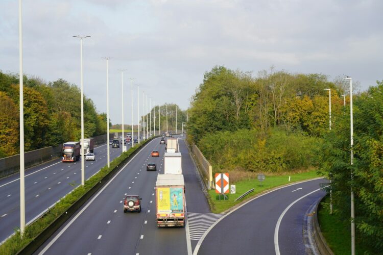 A highway with a bunch of cars driving down it