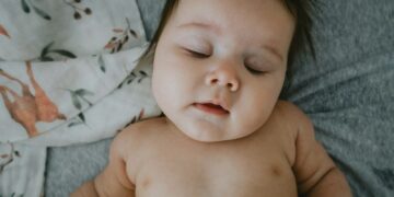 a baby lying on a bed