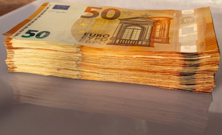 A stack of 50 euro bills sitting on top of a table