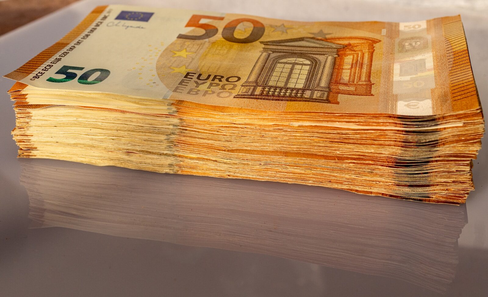 A stack of 50 euro bills sitting on top of a table