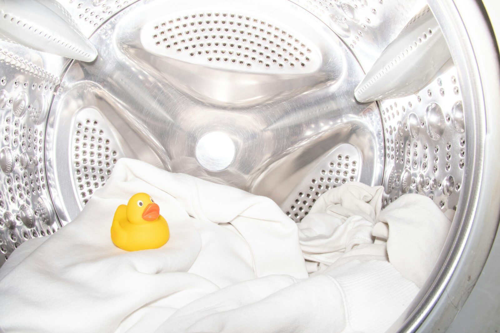 A rubber ducky toy sitting inside of a washing machine
