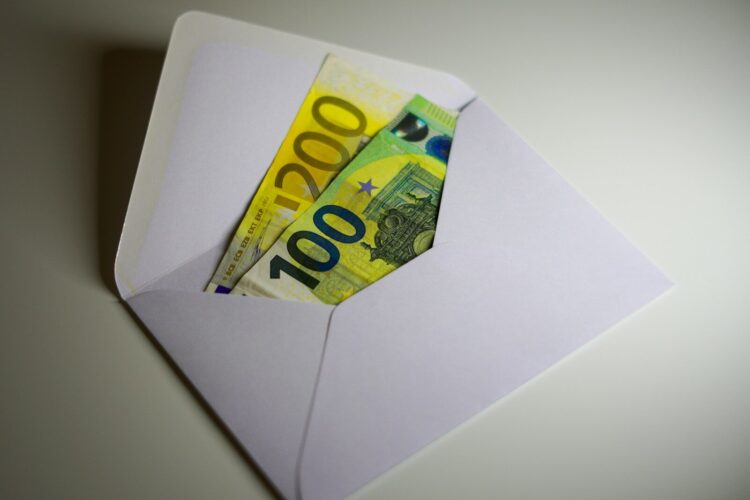 A white envelope with money sticking out of it
