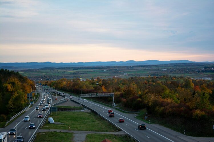 A highway with a bunch of cars driving down it