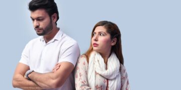 a man and a woman standing next to each other and looking at the camera