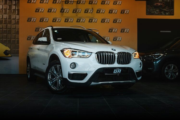 A white bmw suv parked in front of a wall