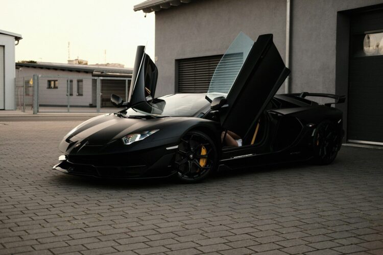 A black sports car parked in front of a garage