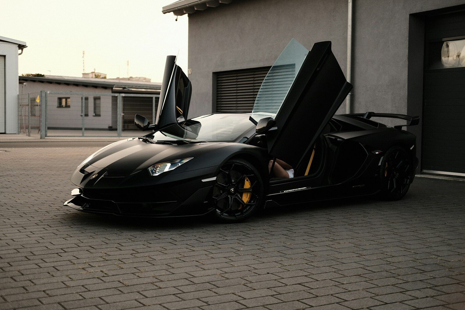 A black sports car parked in front of a garage
