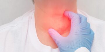 Medical professional in a blue glove pressing a patient’s throat, with a red glow indicating neck pain area.
