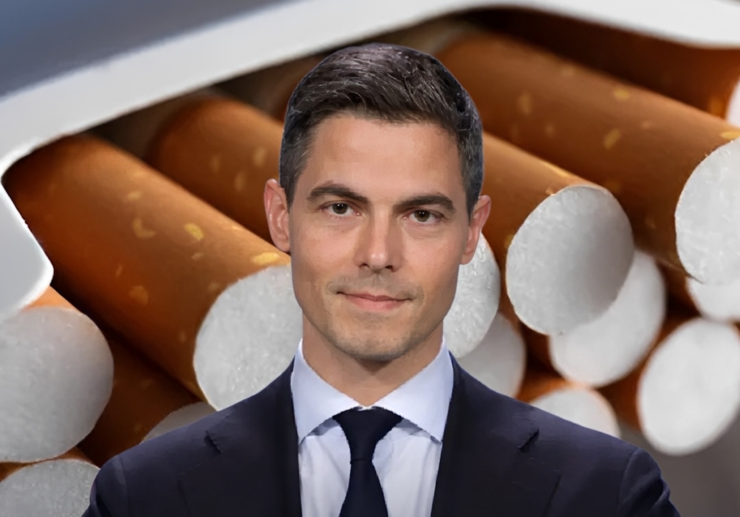 Portrait of a man in a dark suit and tie set against a backdrop of cigarettes stacked behind him