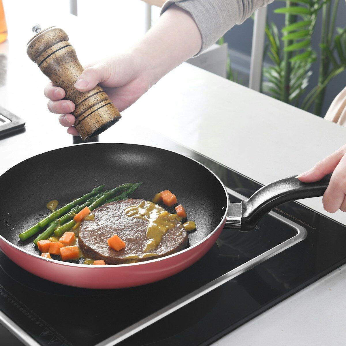 Person holding black and red frying pan