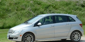 silver sedan on green grass field during daytime