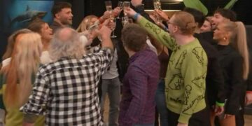 Group of people in a circle toasting with champagne flutes at a party.