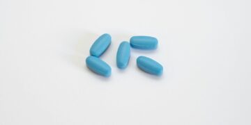 a group of blue pills sitting on top of a white table