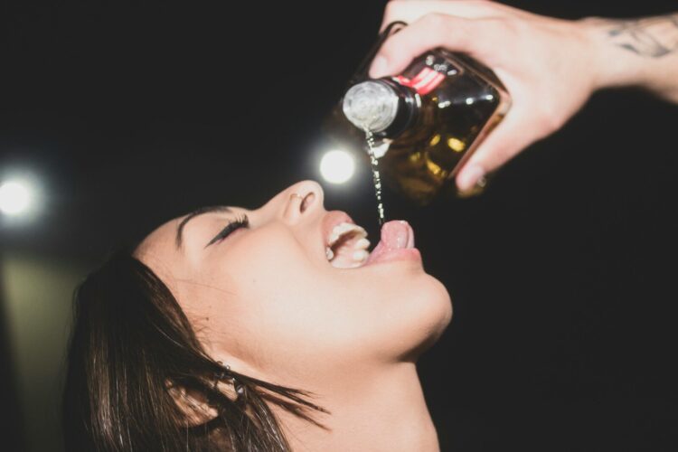 a woman is drinking from a bottle of wine