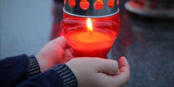 stop adult suicide, candle in child hands, left alone, emotional trauma, traumatic, condolence, mourning, sadness, remembering, grave, cemetery, outdoor