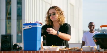 Casual rooftop barbecue scene with friends enjoying a sunny day in Portugal.