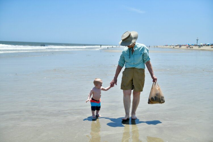 a woman and a child are walking on the beach
