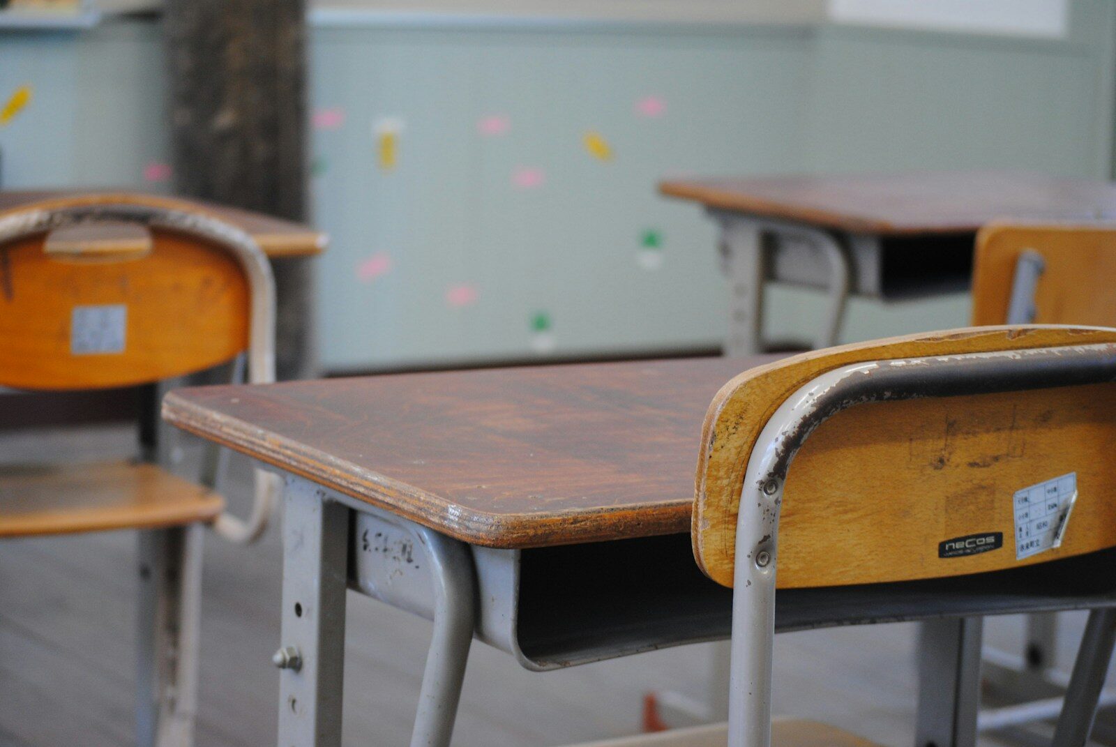 A row of wooden school desks in a classroom