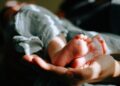 person holding baby feet
