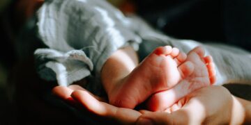 person holding baby feet