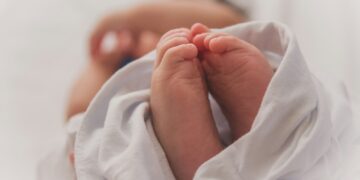 baby covered with white blanket