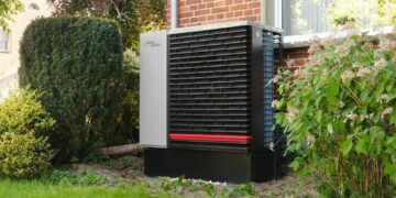 Outdoor heat pump unit next to a brick building.