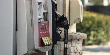 a gas pump next to a brick wall