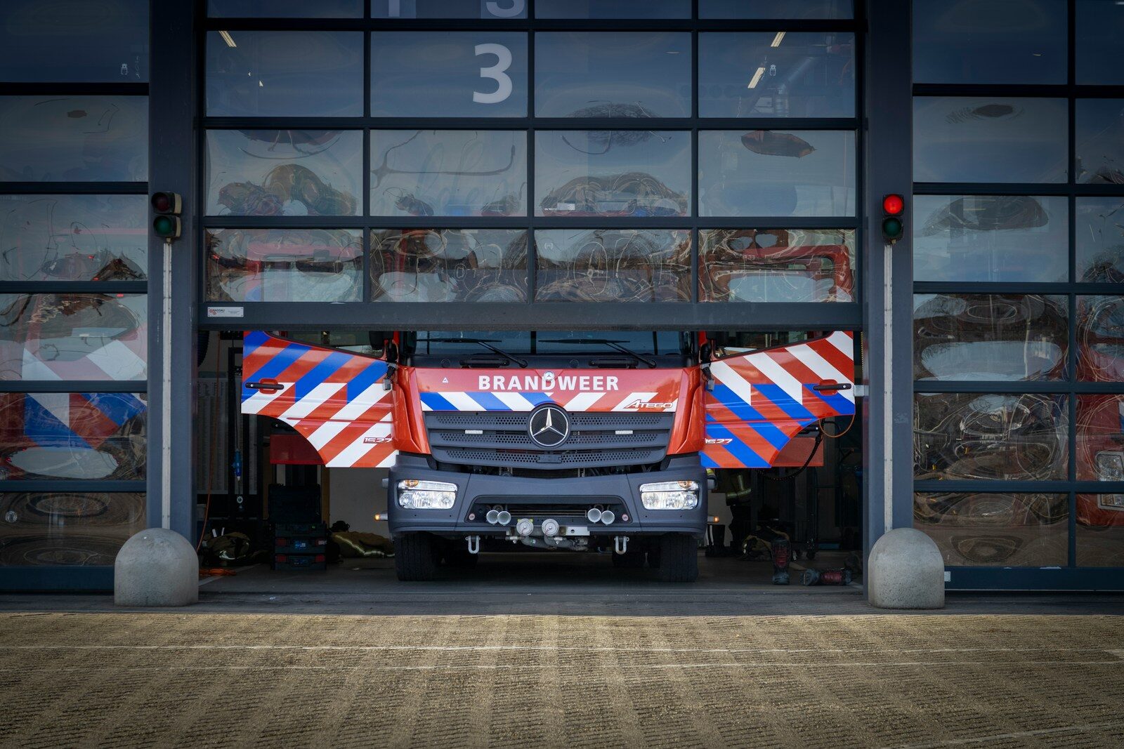 Fire truck exiting a modern fire station garage